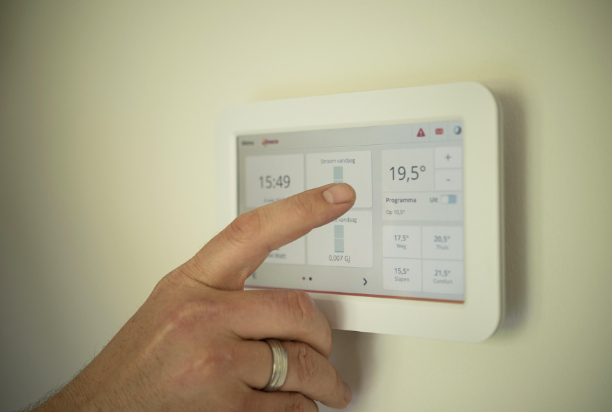 보일러 온도조절 패널을 손으로 설정하는 모습