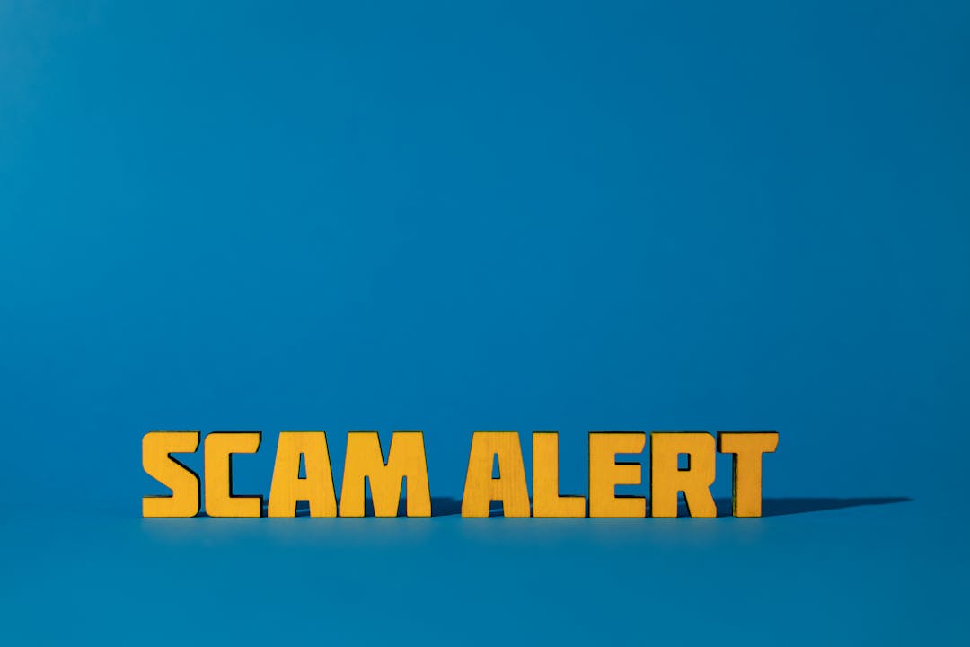 파란 배경 위에 놓인 노란색 SCAM ALERT 경고 문구