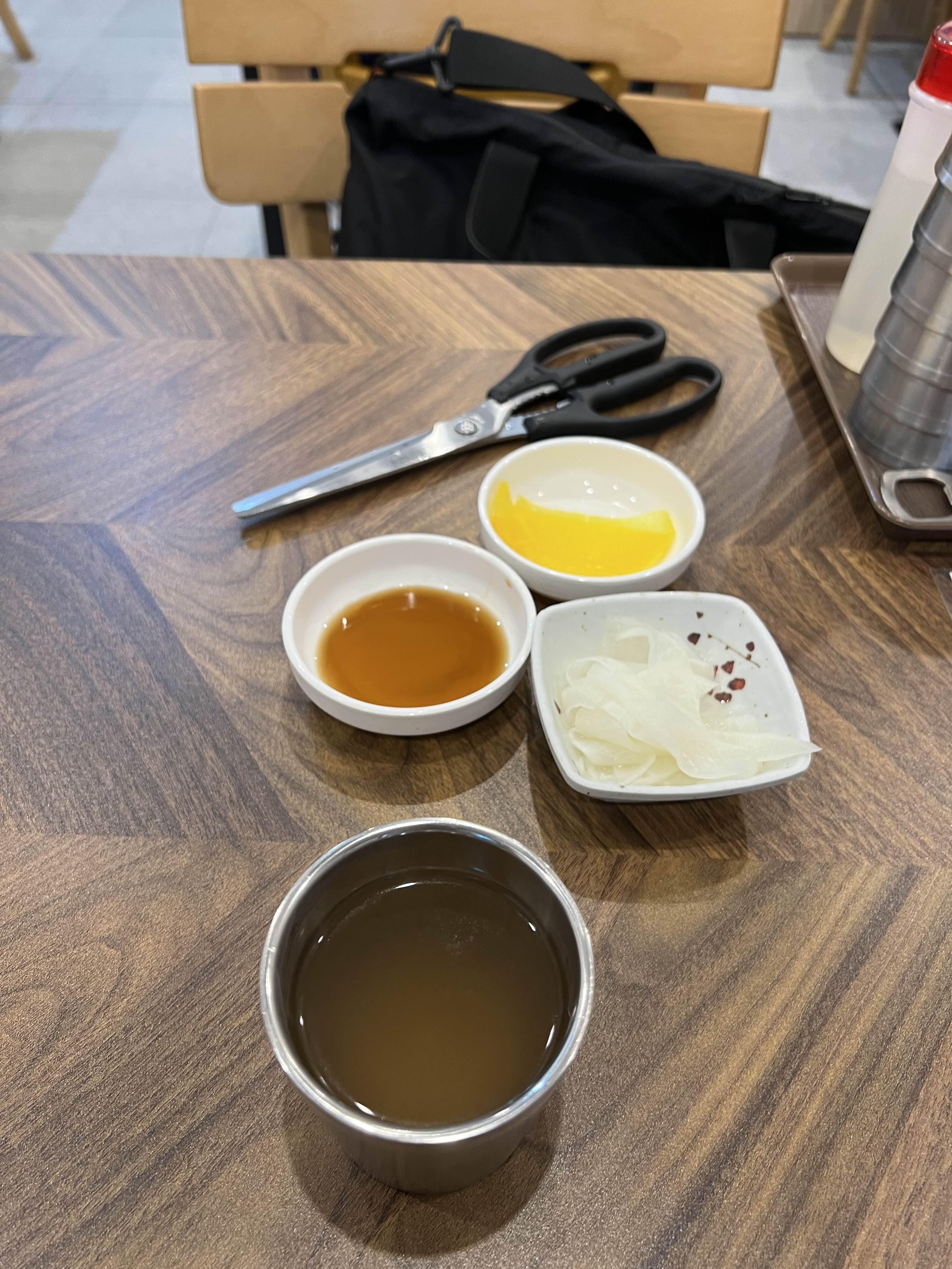 밀면과 만두를 주문 한 뒤의 기본 찬 사진
가위, 단무지, 만두 간장, 무, 육수가 있다.