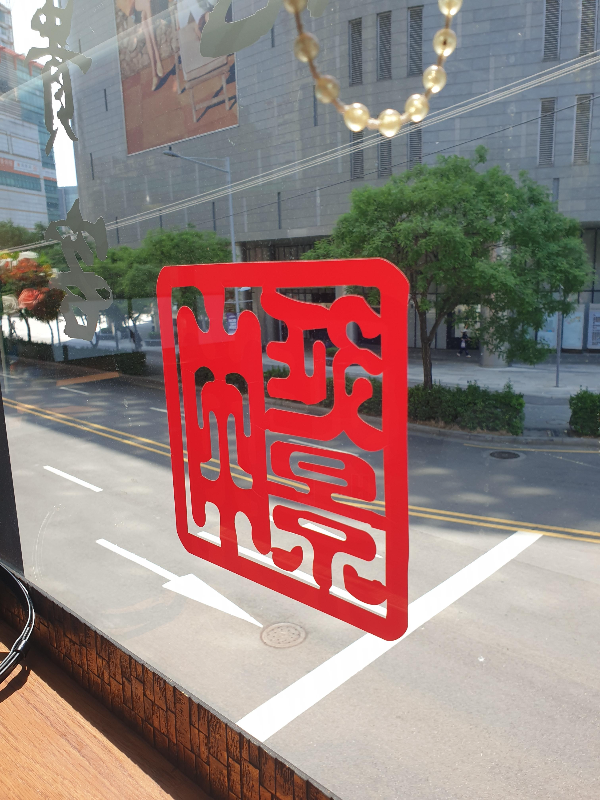 창가에 부착되어 있는 낙관 모양의 붉은 부착물