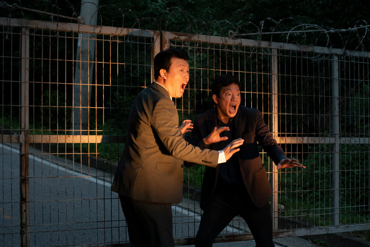 철창 앞에서 불빛을 받고 놀란 두 남자