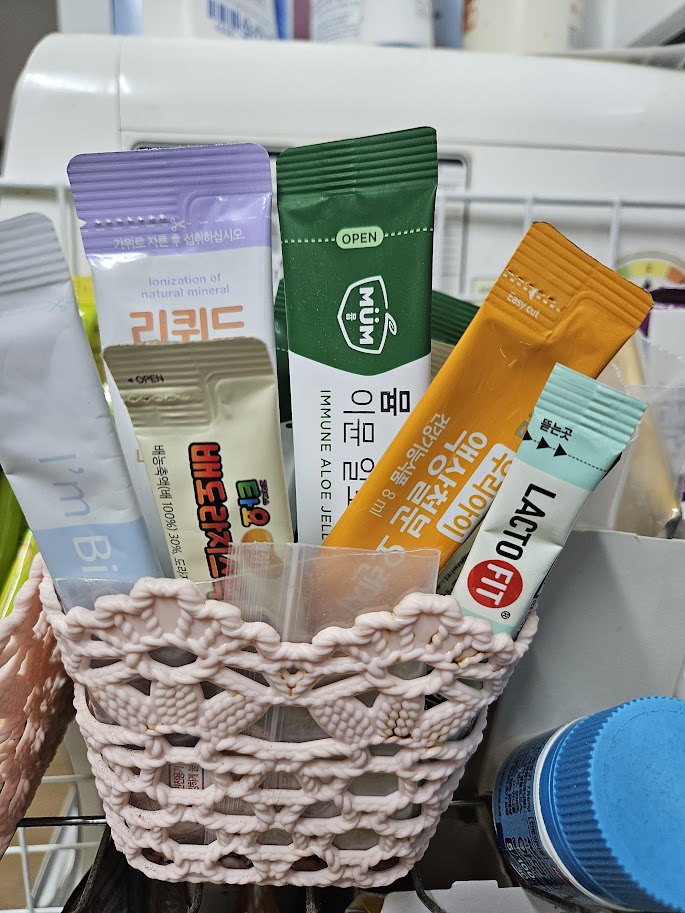 아이가 언제든지 필요할때 꺼내 먹을수 있게 바구니에 들어가 있는 어린이용 비타민과 유산균 영양제 통들이 모여 있는 사진.