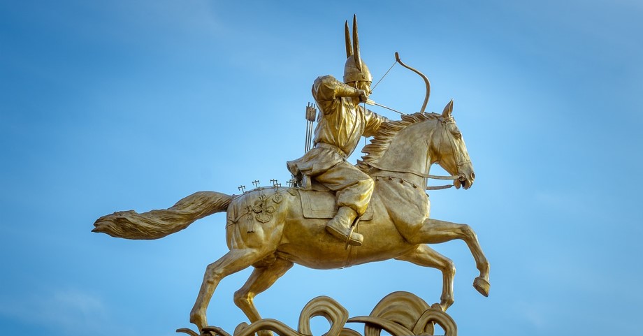 맑고 푸른 하늘을 배경으로, 신라 화랑이 말을 탄 상태에서 활을 쏘는 모습의 동상을 찍은 사진