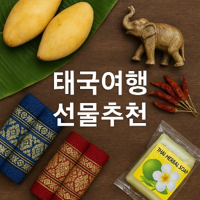 태국 전통 선물들과 &quot;태국여행 선물추천&quot; 문구가 중앙에 배치된 이미지, 망고, 나무 코끼리, 태국 전통 직물, 태국 허브 비누, 말린 고추 등의 태국 전통 아이템이 나무 테이블 위에 정갈하게 배치되어 있음.