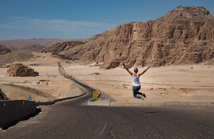 미국의 도로에서 점프 샷을 찍고 있는 여자 뒷모습