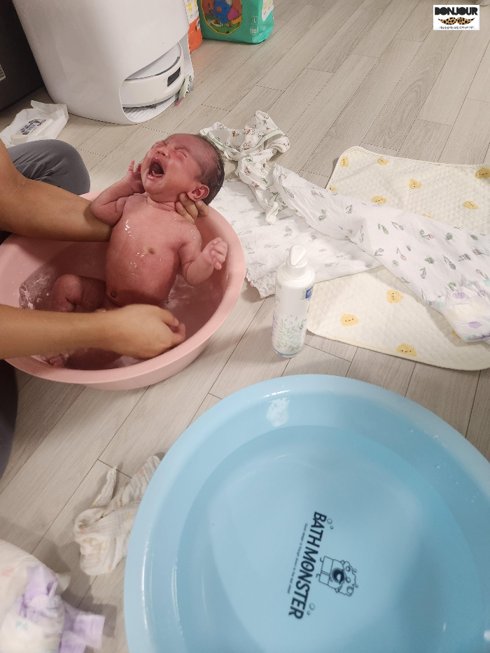 비눗물과 깨끗한물로 나눠서 목욕을 하는 신생아의 모습