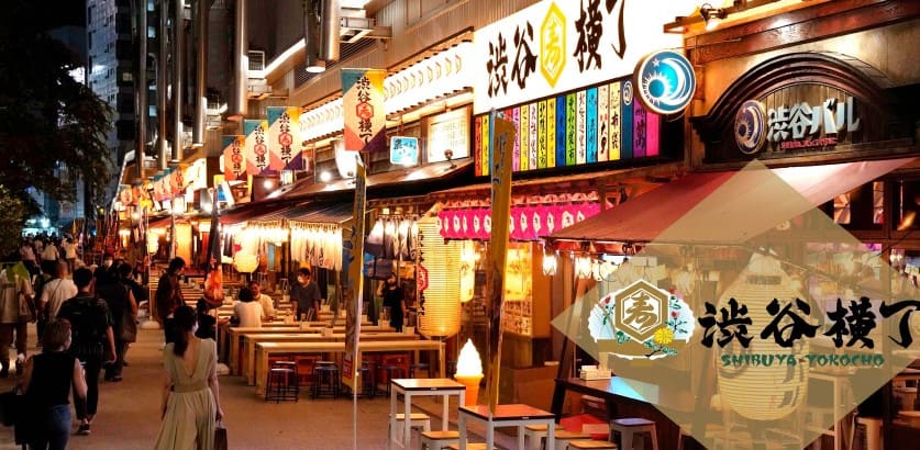 길거리에 상점이 늘어서 있고 왼쪽편에 사람들이 있다