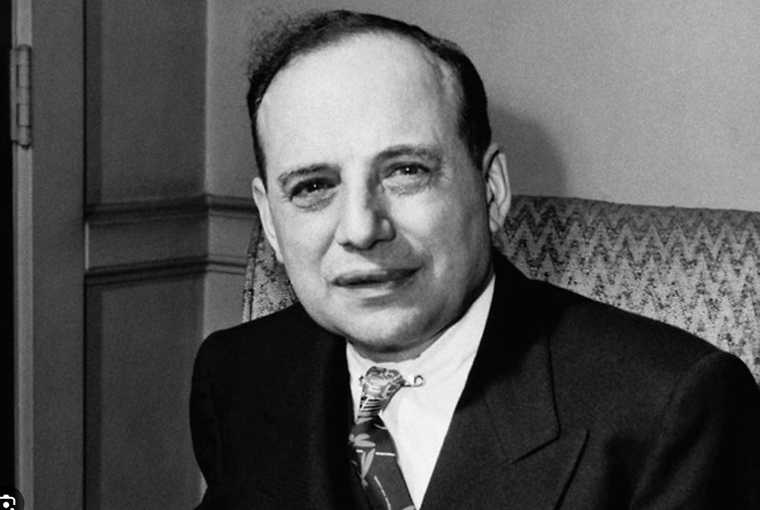 흑백-톤의-정장-차림으로 미소-짓는-벤저민-그레이엄,-가치-투자의-선구자이자-금융-전문가의-상징적-모습.