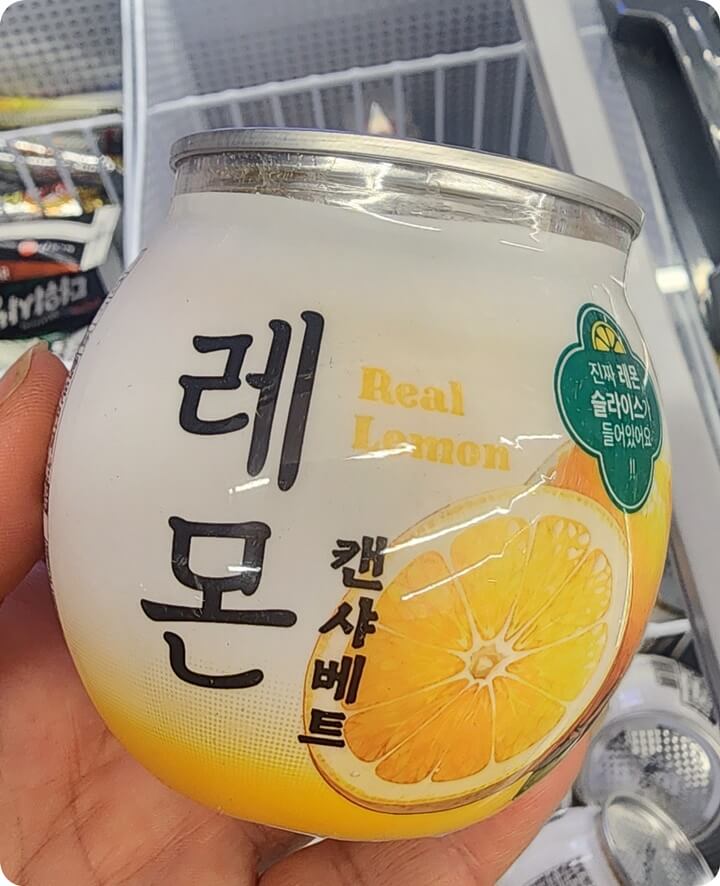 레몬 주스 캔을 들고 있는 손