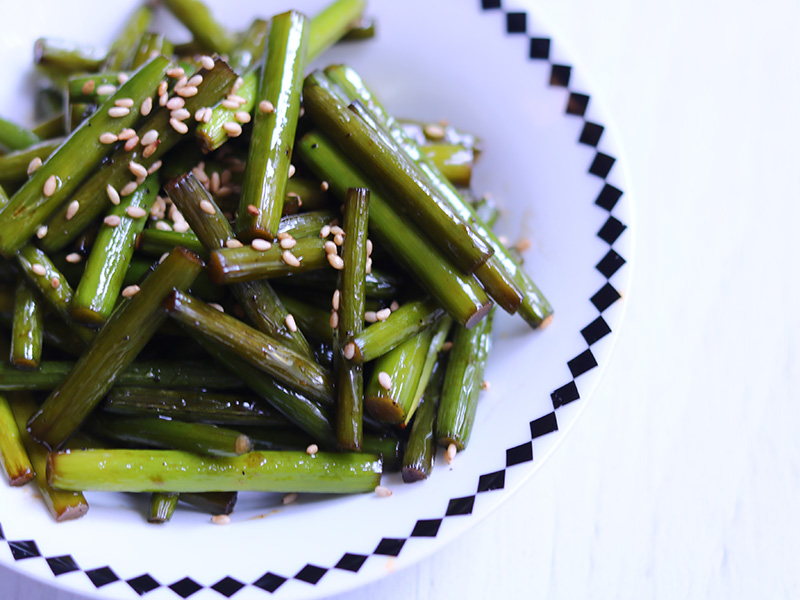 흰접시에 담은 깨 뿌린 마늘쫑