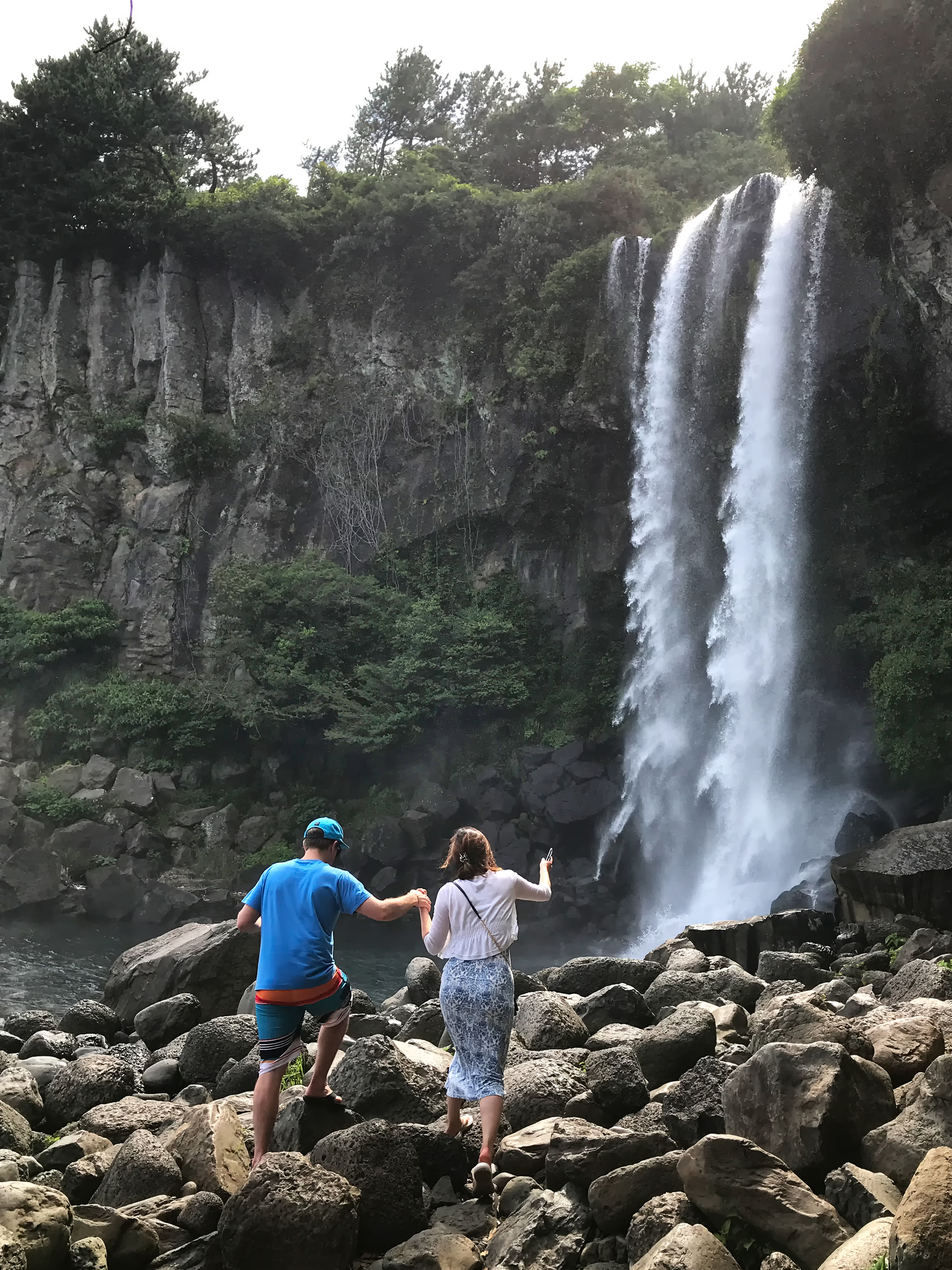 제주도 서귀포시 정방폭포 아래 험한 돌길에서 서로의 손을 잡고 걷는 커플 by 피어나네 저작권 없는 고화질 무료 이미지 바로가기