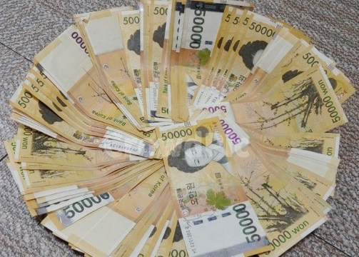 바닥에 둥글게 놓여있는 오 만원 지폐 사진