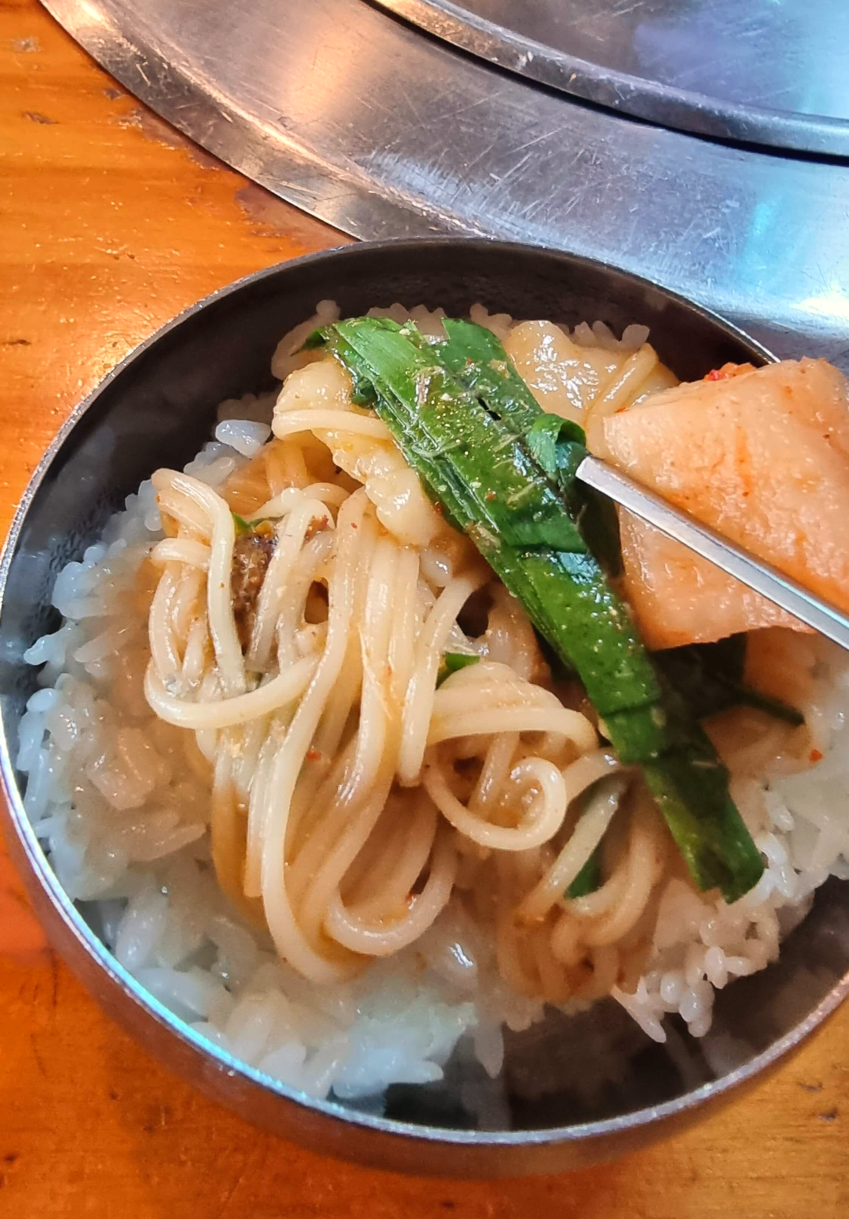 어죽 안에 국수와 부추 그리고 깍두기 한젓가락