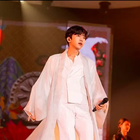 임영웅- 흰색 한복 겉옷을 입고 안에는 흰색 수트를 입고 왼손으로 마이크를 쥔채 앞을 보고있는 임영웅