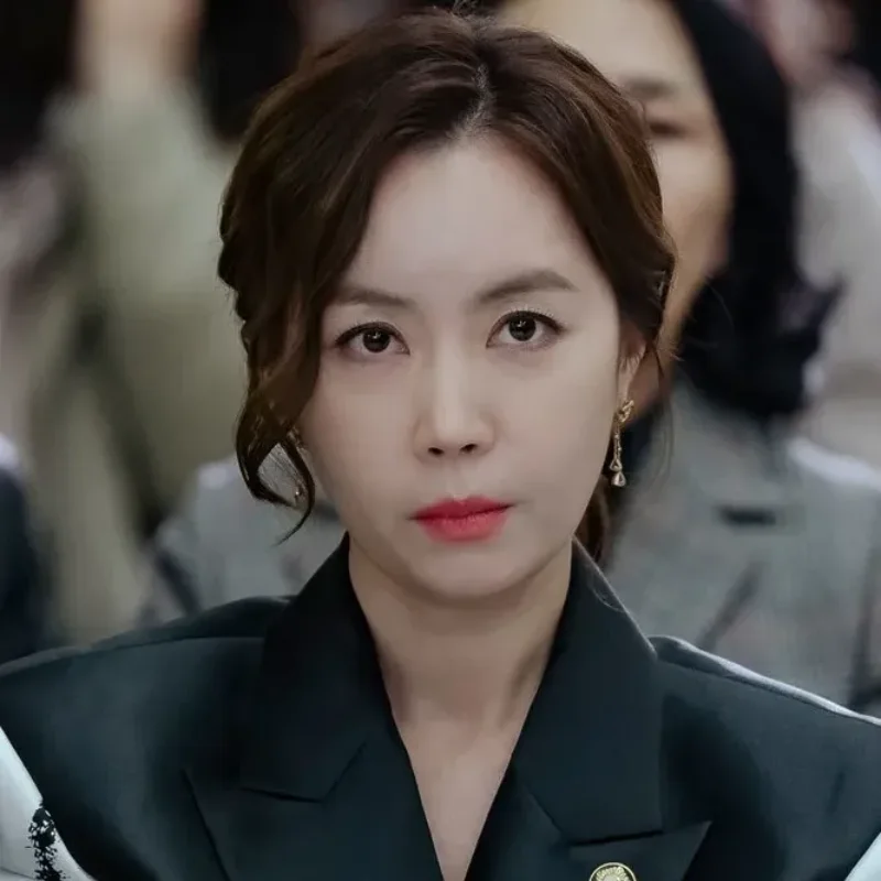 여러 사람들이 앉아 있는 실내에 검은 정장을 입고 우아하고 섹시한 국민사형투표의 민지영