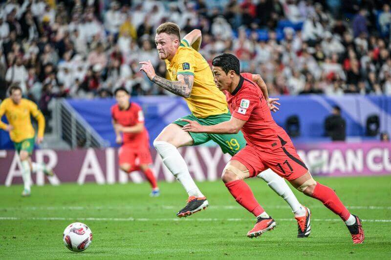 뛰어가는 호주 선수와 황희찬 선수