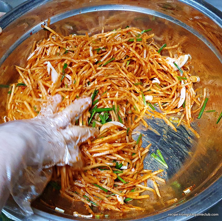 무생채 무침에 준비된 야채(부추, 양파, 파)를 넣고 고루 섞어주는 사진