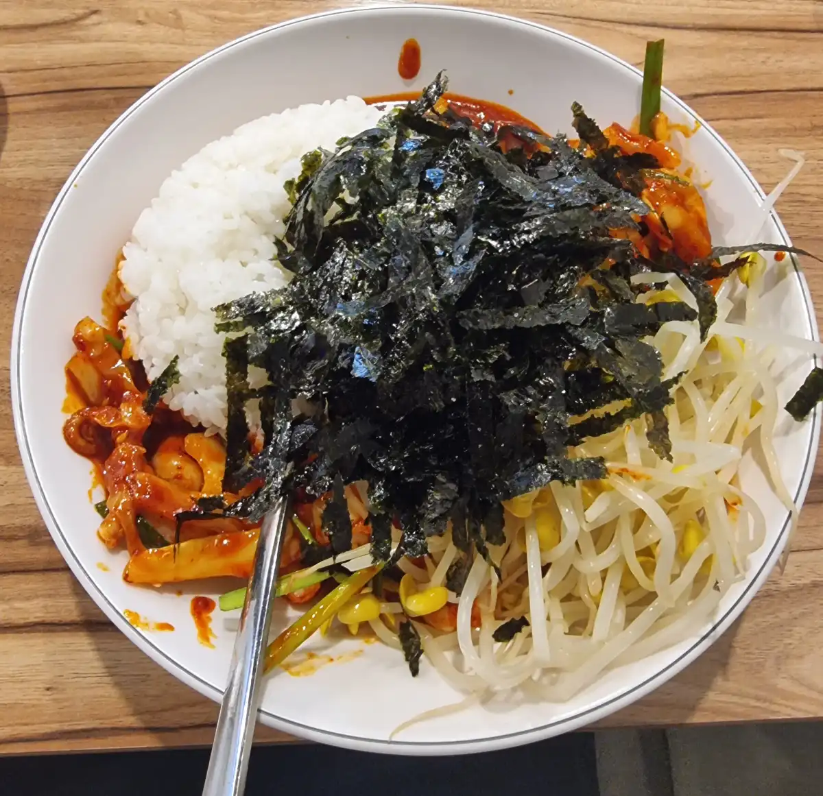 그릇에 김가루와 콩나물, 낙지볶음, 공기밥을 모두 투하한 사진