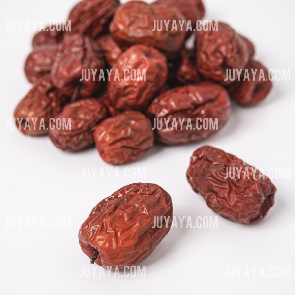 흰 배경 위에 놓인 말린 대추들. 부드럽고 건강한 맛을 자랑하는 겨울철 건강 간식.