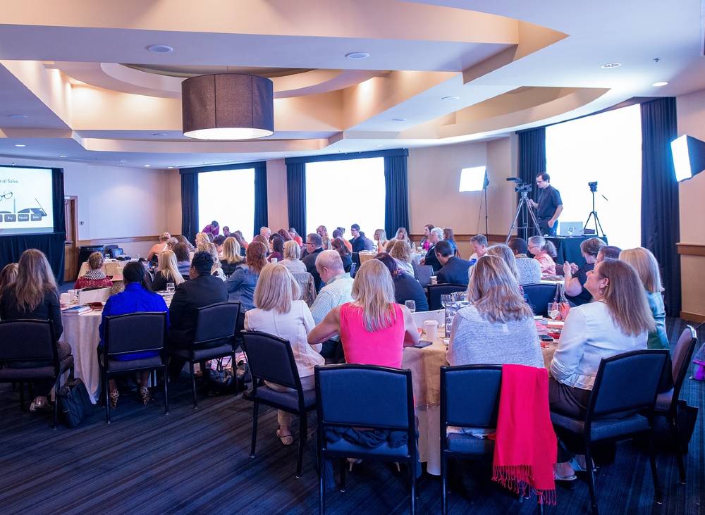 많은 사람들이 커다란 원형테이블에 둘러 앉아 영상을 시청하고 있다