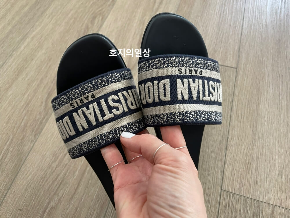 손으로 든 디올 디웨이 뮬 슬리퍼