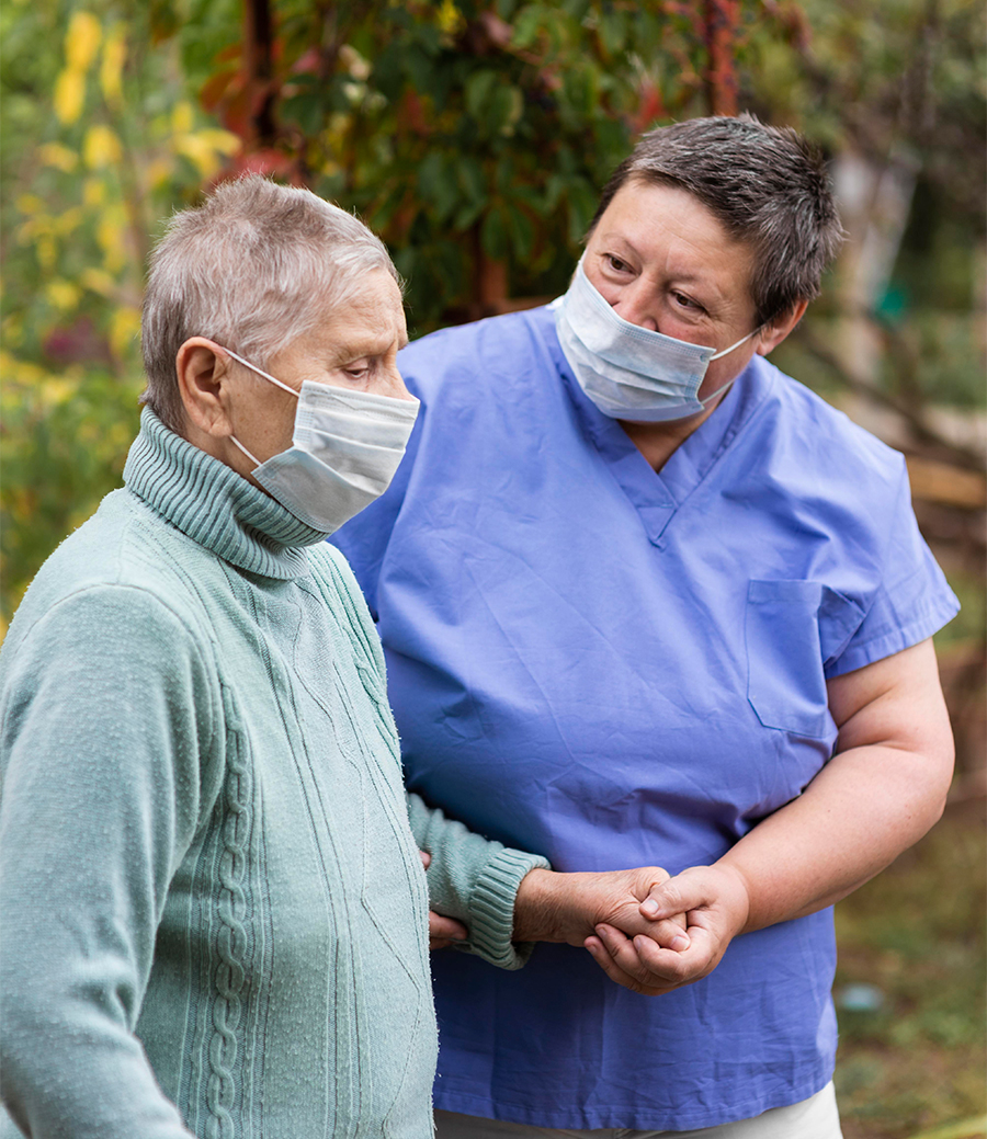 나이든 환자의 손을 꼭 잡은 요양보호사의 사진