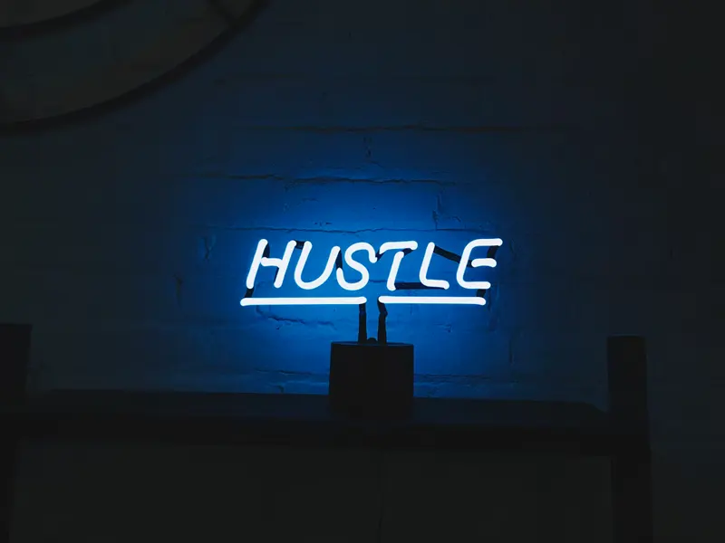 불 꺼진 방에 HUSTLE 레터링으로 된 파란 무드등이 켜져 있다.