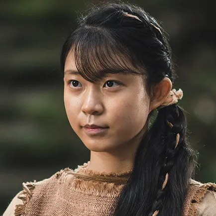 긴 머리를 댕기처럼 꼬아 내린 20대 여성이 갈색 옷을 입고 서 있는 아라문의 검 모아 캐릭터