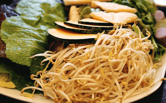 하얀 접시에 숙주나물 한뭉치와 호박 슬라이스와 상추들이 가득 담겨있다.