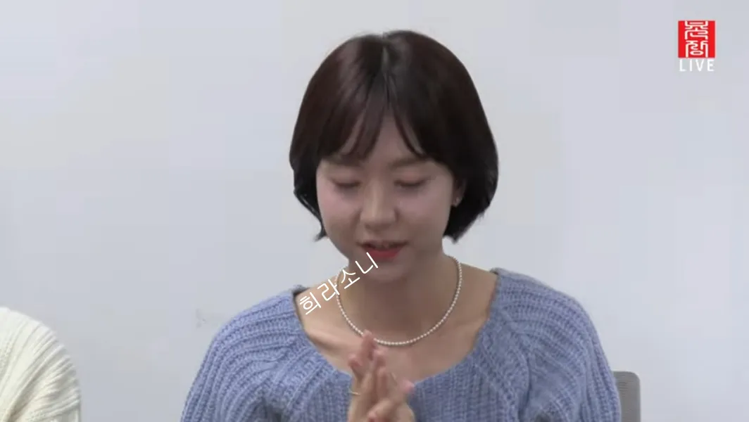 파란색 니트를 입고 진주 목걸이를 한 현숙.