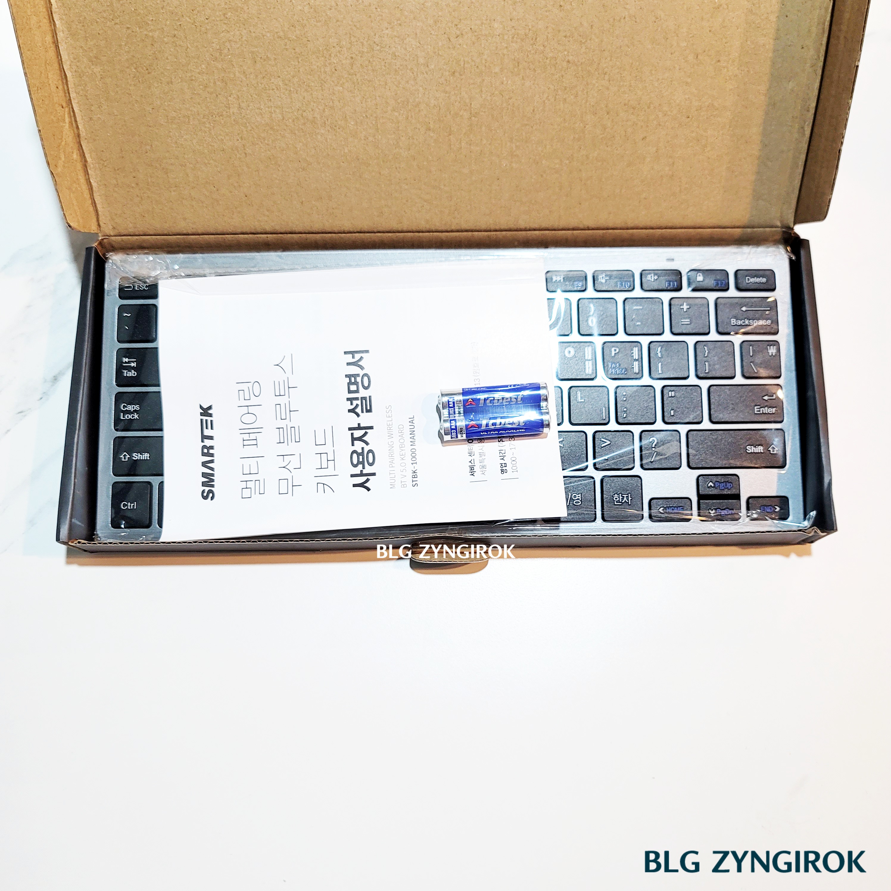 노브랜드 전자기기 : 무선 키보드 구성품 모습이다. 설명서, 키보드, 베터리가 상자에 들어있다.