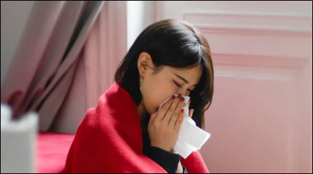 코를 풀고 있는 여성의 옆 모습