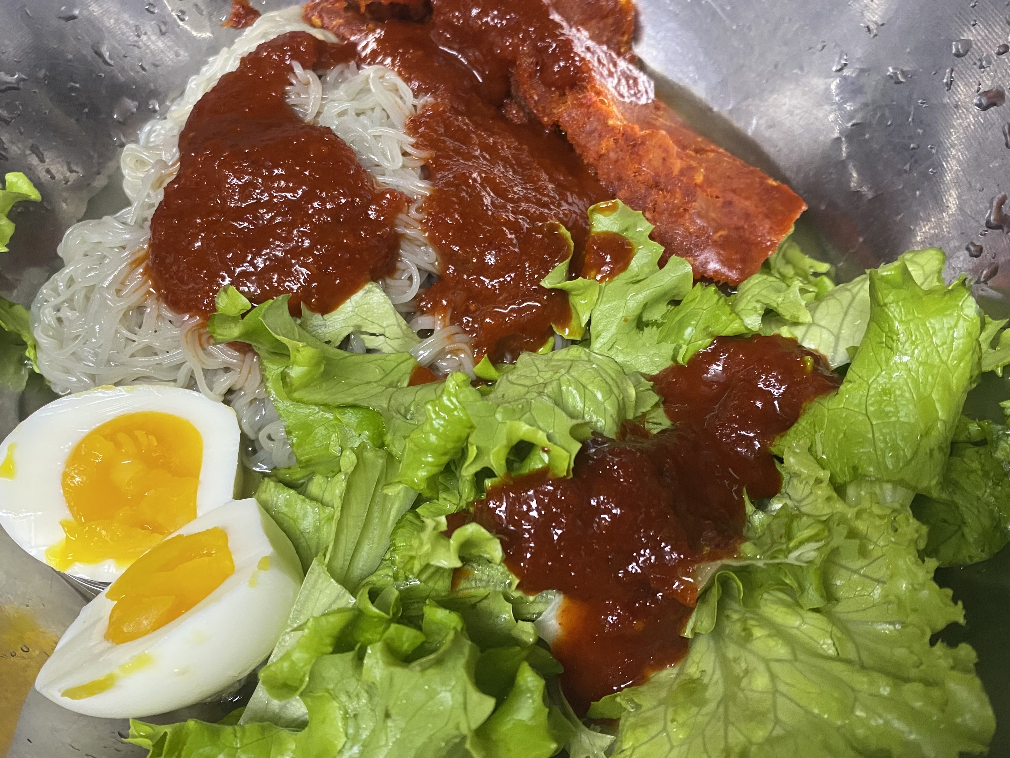 양푼안에 냉면, 양념장, 상추, 반숙란, 명태회가 올려져 있는 모습입니다.