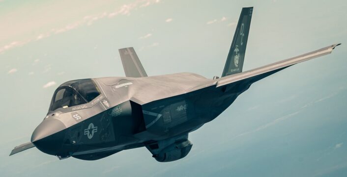 F-35B가 외장형 기총 포드를 장착하고 비행하고 있으며 기총 포드의 전면 총구가 보인다.