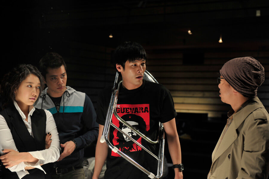 연극 연출자들과 의자를 목에 걸고 있는 남자