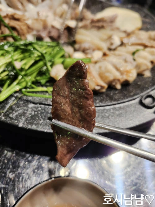 쫄깃한 식감의 염통 한 조각을 젓가락으로 집은 모습