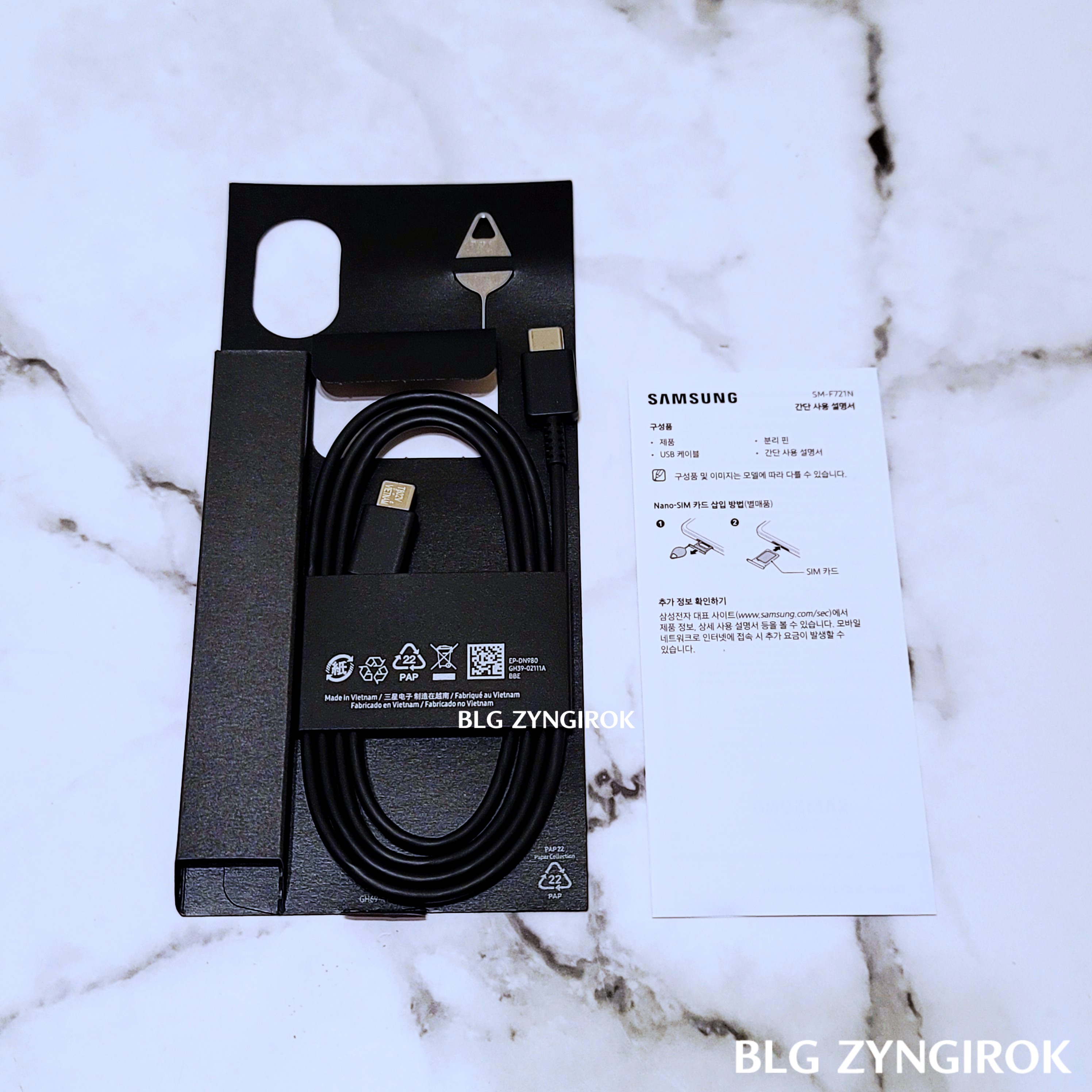 뚜껑부분에-들어있는-구성품들을-테이블에-놓은-모습이다.-유심핀-USBC-케이블-간단-설명서가-놓여있다.