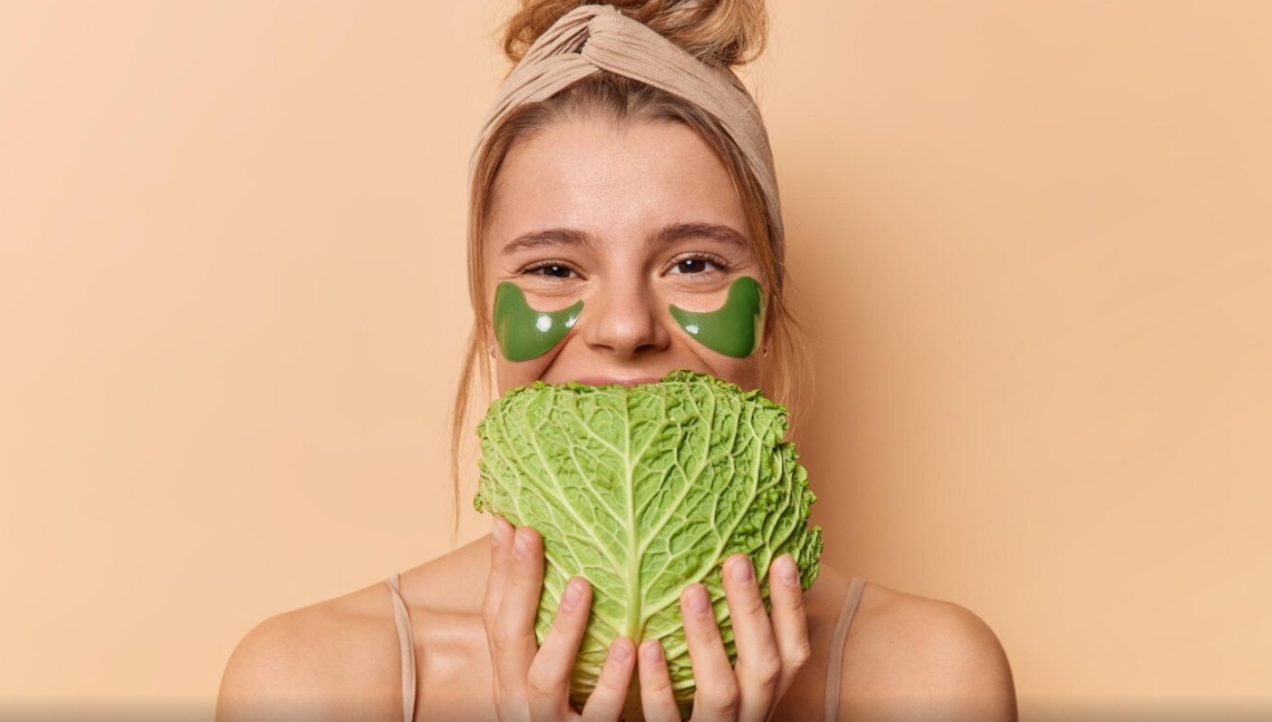 야채를 입에 대고 귀엽게 웃고 있는 여성