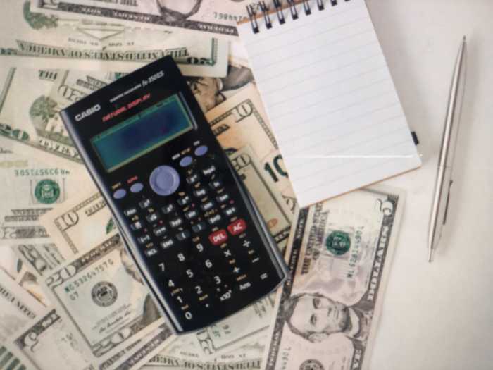 계산기와 메모를 위한 수첩 달러가 함께 있는 사진