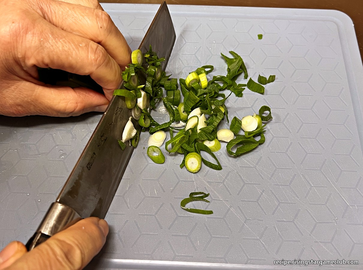 간단한 치킨 닭죽에 고명으로 들어갈 대파를 썰어주는 사진