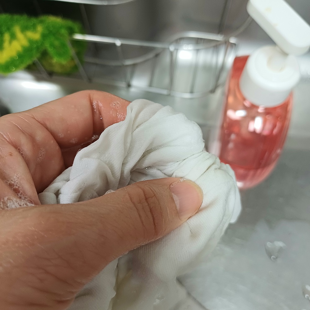 중성세제로 흰 티 커피 얼룩을 손세탁하는 모습