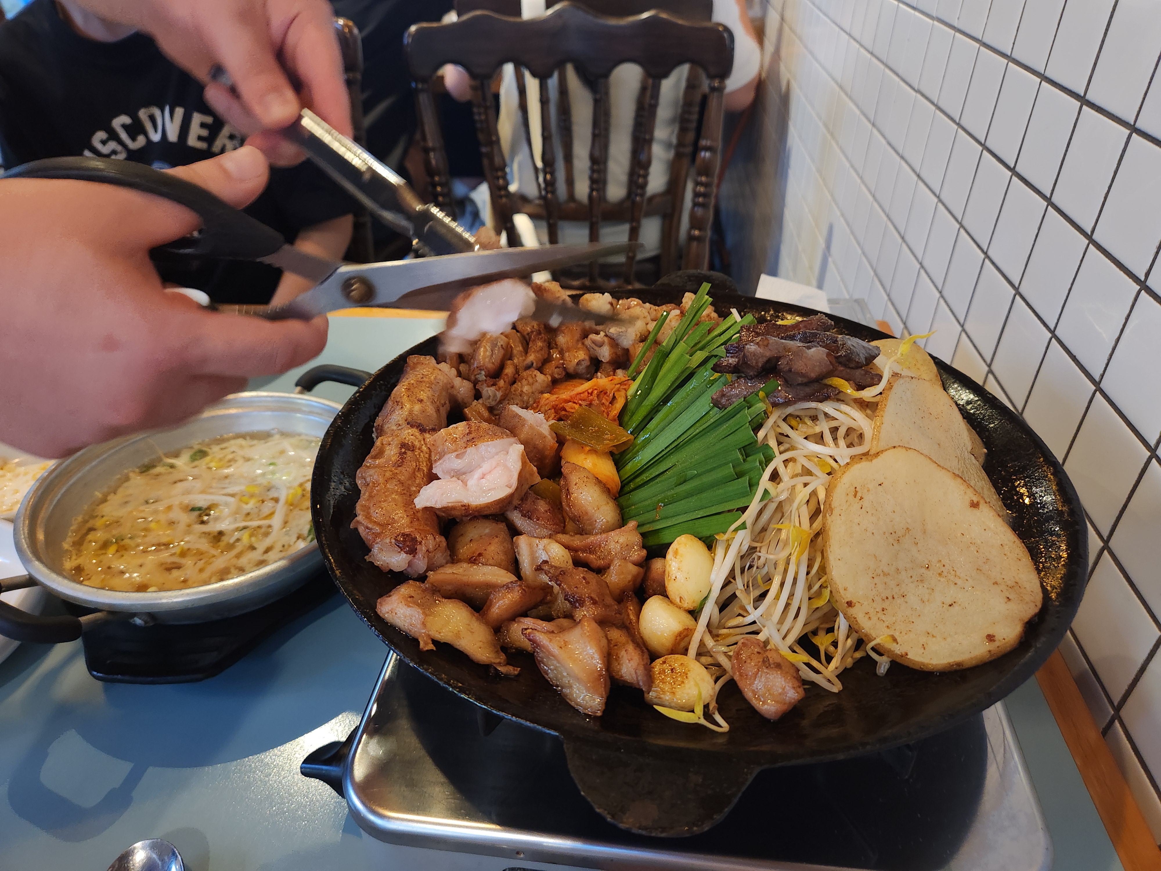 막창구이 모둠을 가위로 자르고 있다.