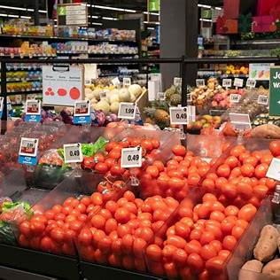 미국 대형마트의 식품 코너에서 진열된 신선한 채소와 다양한 식료품들