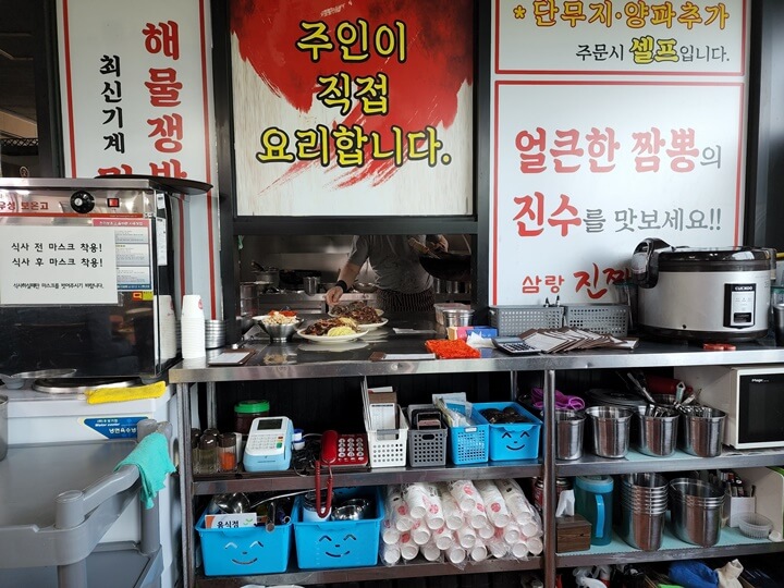 주인이 직접 요리한다는 팻말과 주방에서 홀로 나오고 있는 짜장면