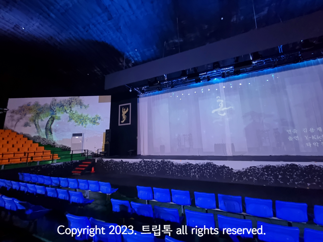 무대를 중심으로 왼쪽에 주황색 좌석들이 있다.