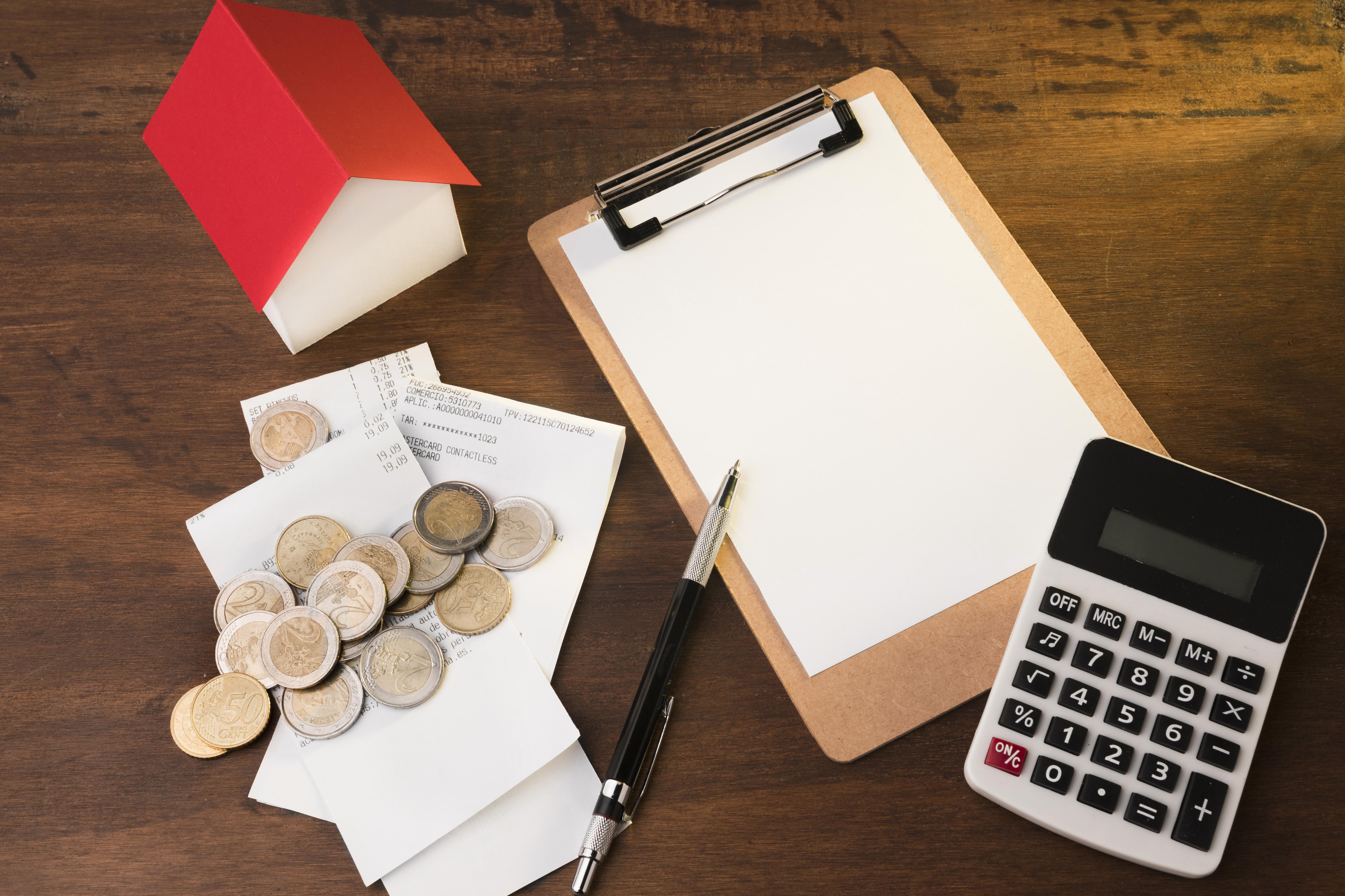 가계부와 동전, 계산기 등으로 생활비를 계획하는 장면