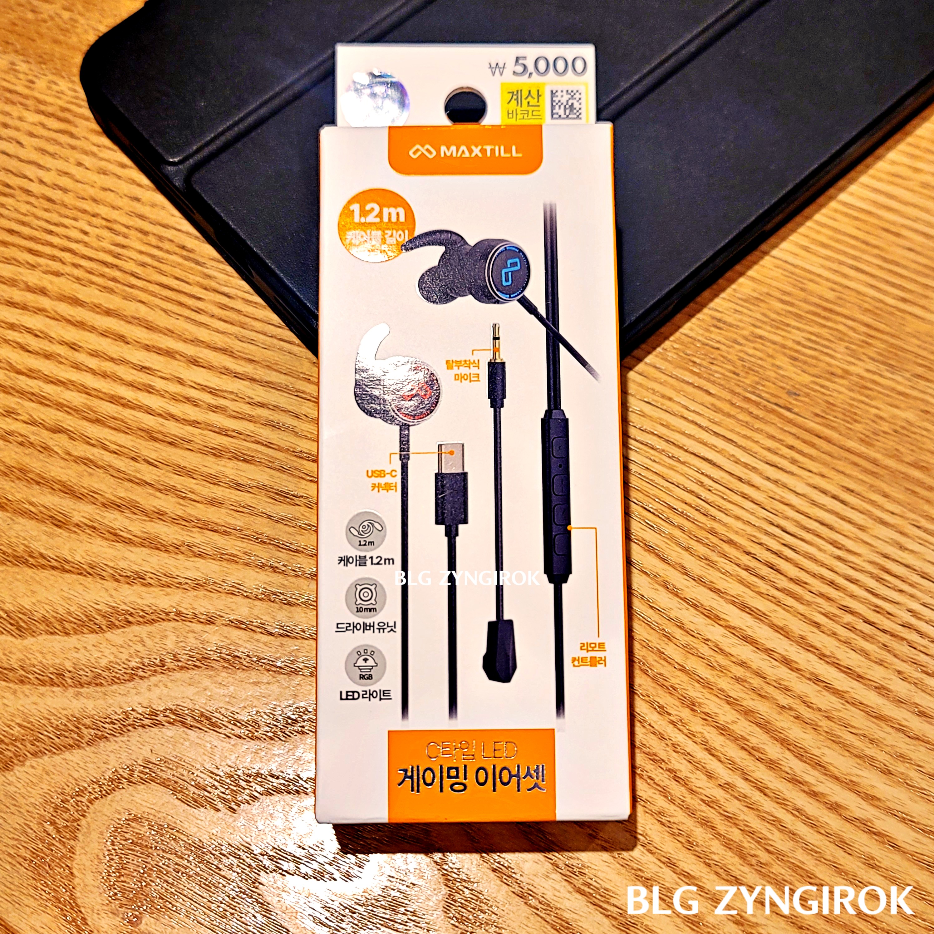 다이소 - MAXTILL 게이밍 이어폰 상자가 앞면이 보이도록 테이블 위에 놓여있다.