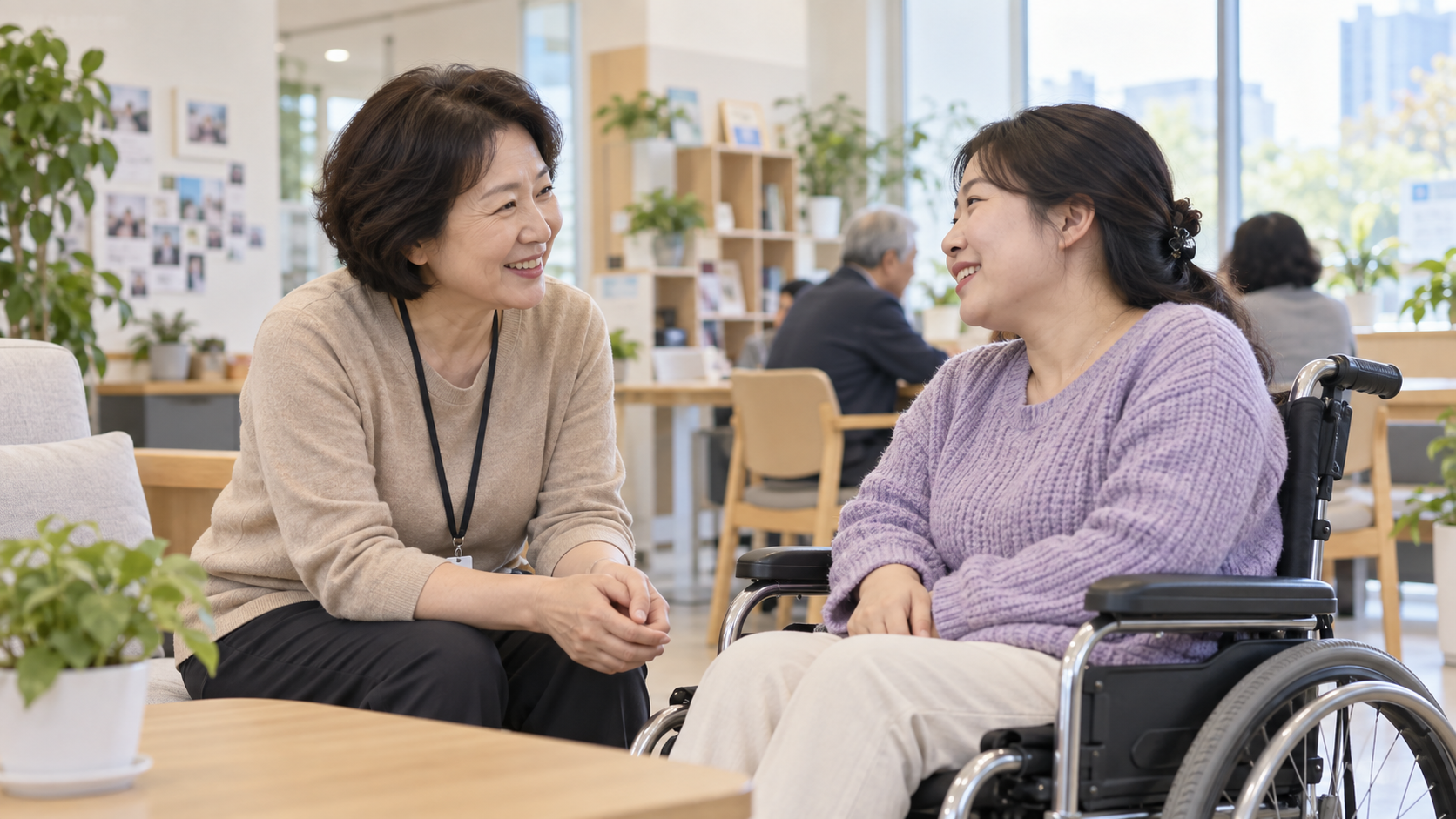 50대 장애인활동지원사가 휠체어 이용자와 상담하는 모습