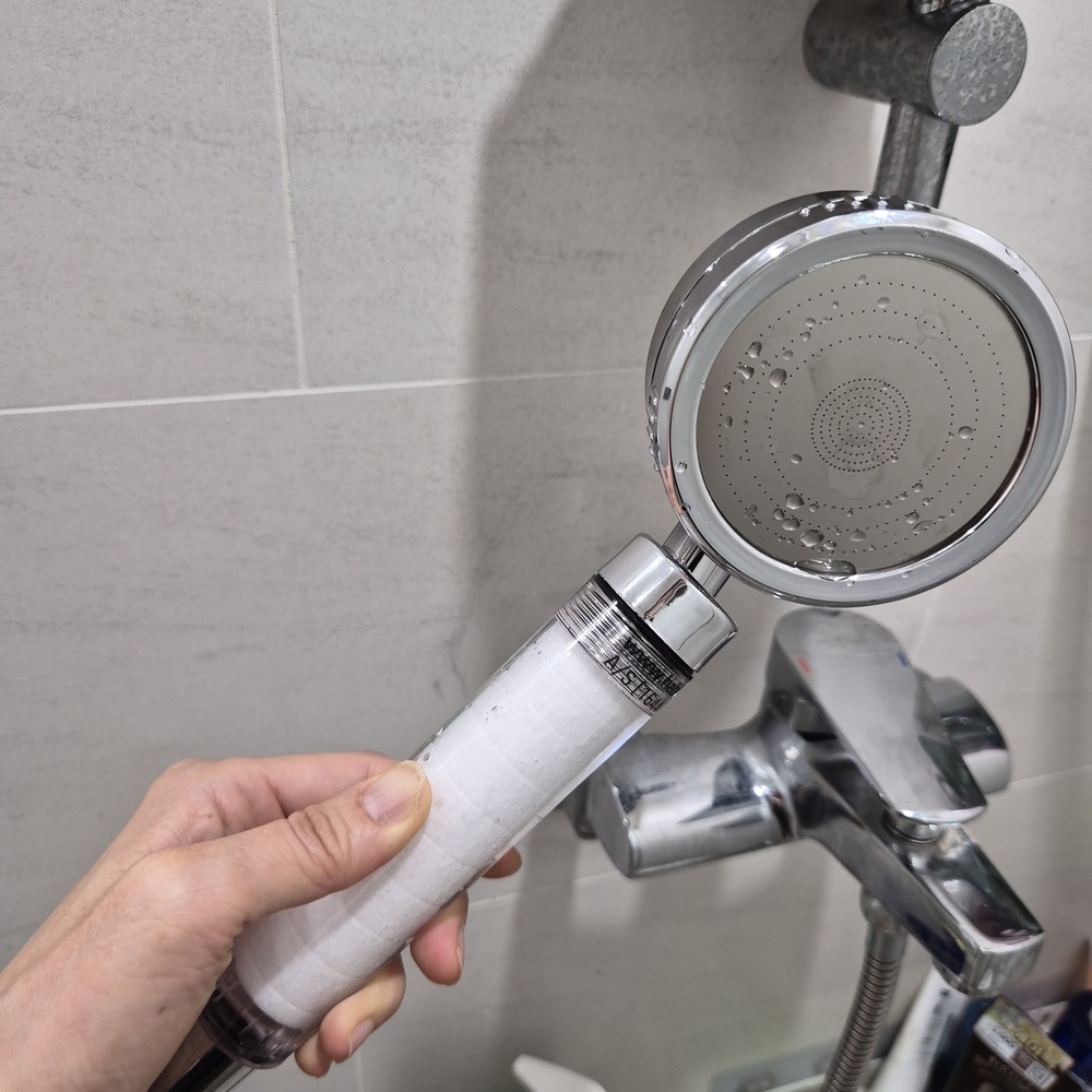 필터가 장착된 깨끗한 새 샤워기 헤드로 교체를 완료하고 물을 틀어본 모습