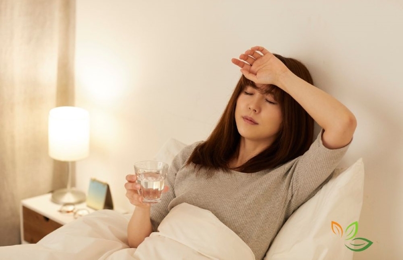 냉방병으로 두통을 호소하며 이마에 손을 대고 물을 마시는 여성, 에어컨 사용 후 나타나는 증상 via canva